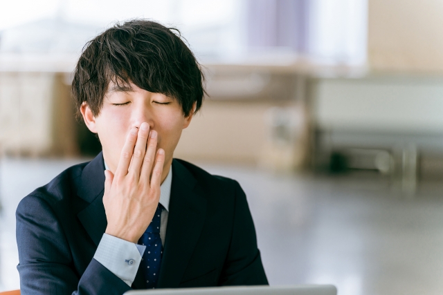 仕事中にあくびをする男性